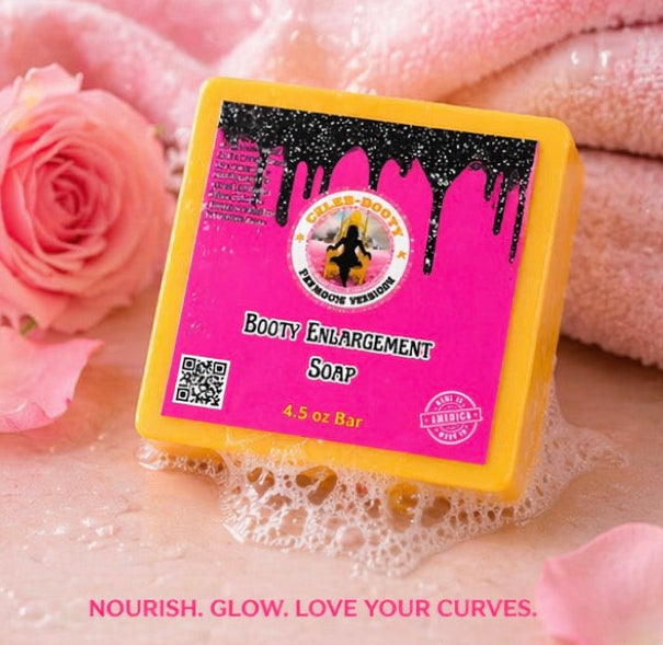 Bar of soap with pink label and yellow border on a textured surface with pink roses and fabric.
